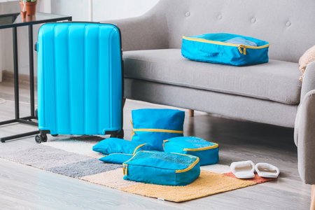 Suitcase and set of travel organizers with accessories at homeの写真素材