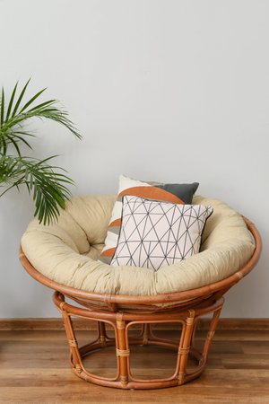 Armchair with soft cushions near light wall in roomの写真素材