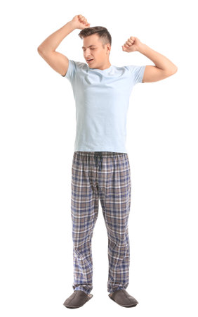 Young man suffering from sleep deprivation on white backgroundの写真素材