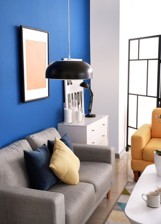 Stylish interior of living room with sofa and lampの写真素材