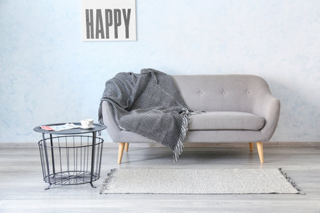 Stylish sofa and table near white wallの写真素材