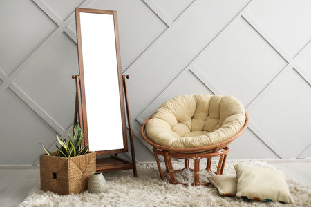 Big mirror with armchair near gray wall in roomの写真素材