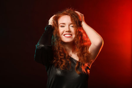Portrait of beautiful redhead woman on dark backgroundの写真素材