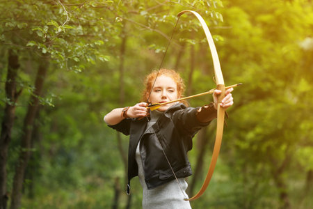 Sporty young woman practicing archery outdoorsの写真素材