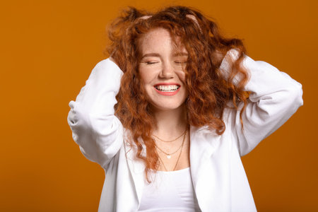 Portrait of beautiful redhead woman on color background