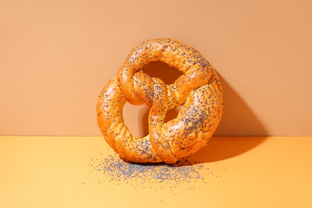 Delicious pretzel with poppy seeds on color backgroundの写真素材