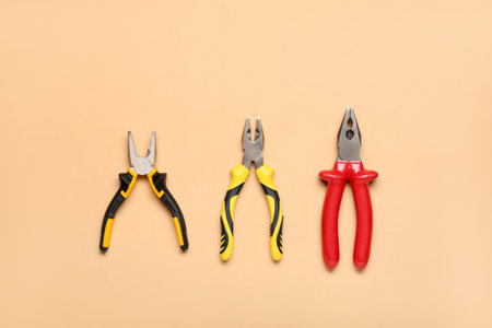 Different pliers on beige backgroundの写真素材
