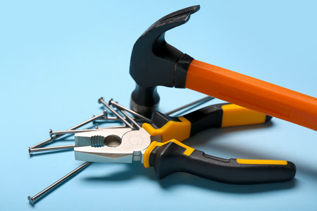 Pliers, hammer and nails on blue backgroundの写真素材