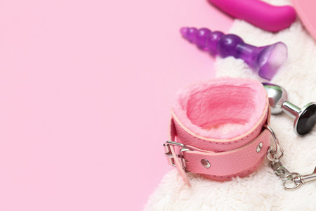 Handcuffs from sex shop with blanket on pink background, closeupの写真素材