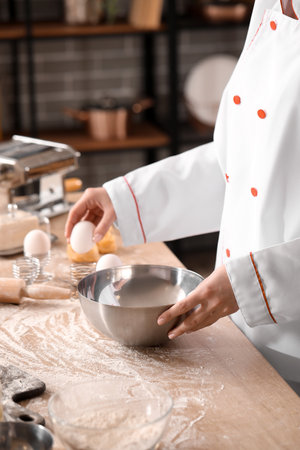 Female chef making dough for pasta at table in kitchen, closeupの写真素材
