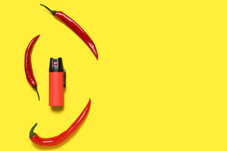 Spray with chili peppers on yellow backgroundの写真素材