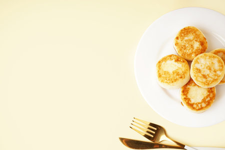 Plate of delicious cottage cheese pancakes on color backgroundの写真素材