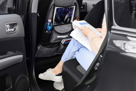 woman reading newspaper in salon of carの写真素材