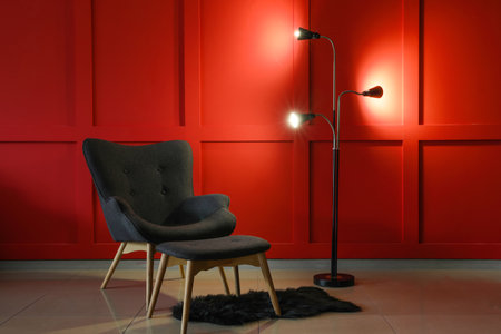 Comfortable armchair and lamp in interior of living roomの写真素材