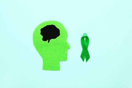 Human head with green awareness ribbon on color background. concept of dementiaの写真素材