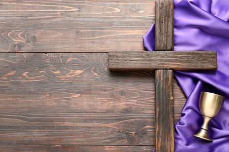 Cross with wine cup and purple fabric on wooden background. good friday conceptの写真素材