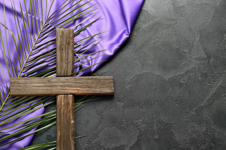 Wooden cross with palm leaf and purple fabric on dark background. good friday conceptの写真素材