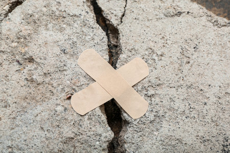 Cracked stone with medical plasters, closeup. Turkey and Syria earthquake conceptの写真素材
