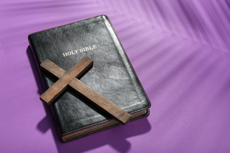 Wooden cross with Holy Bible on violet background. good friday conceptの写真素材