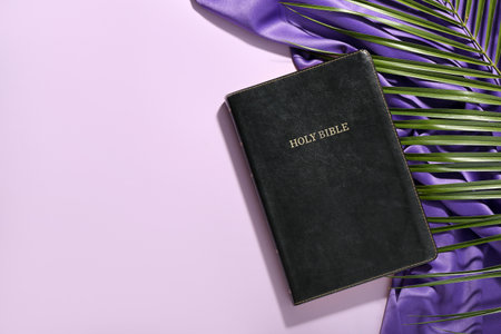Holy Bible with palm leaf and purple fabric on lilac background. good friday conceptの写真素材
