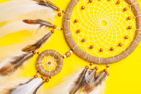 Beautiful dream catcher on yellow background, closeupの写真素材