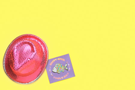 Card with text HAPPY APRIL FOOLS DAY and party hat on yellow backgroundの写真素材