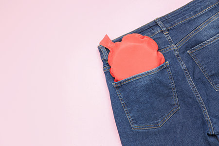 Jeans with whoopee cushion on pink background. April Fools' Day celebrationの写真素材