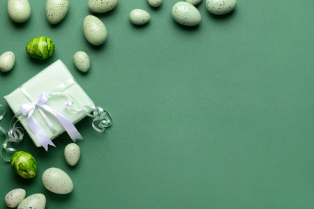Frame made of Easter eggs with gift on green backgroundの写真素材