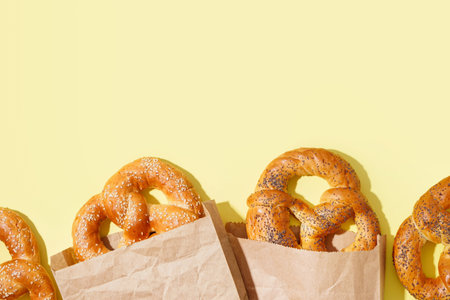 Paper bags with tasty pretzels on color backgroundの写真素材