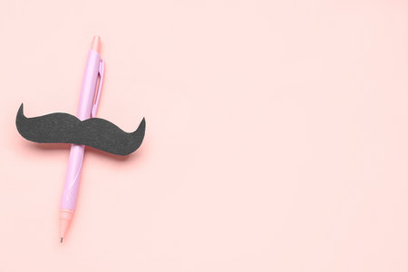 Pen with paper mustache on pink backgroundの写真素材