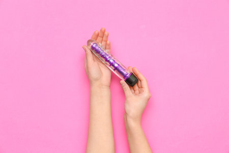 Woman with vibrator from sex shop on pink backgroundの写真素材