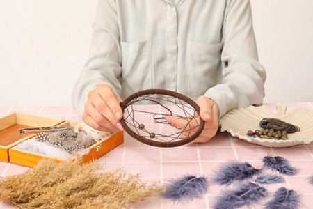 Woman making dream catcher on pink tile table, closeupの写真素材