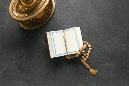 Koran with prayer beads and lantern for Ramadan on dark background