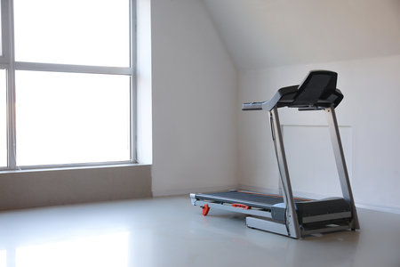 Interior of room with modern treadmill near windowの写真素材