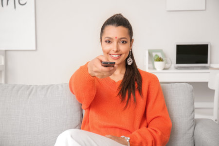 Young woman watching TV at home