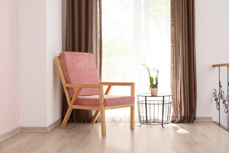 Stylish armchair near window in roomの写真素材