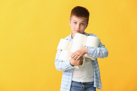 Funny little boy with toilet paper on color backgroundの写真素材
