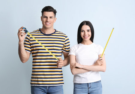 couple with measuring tapes on color backgroundの写真素材