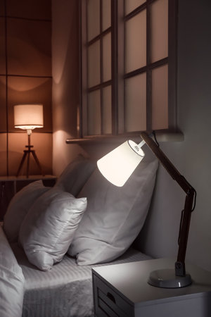 Interior of modern hotel room with glowing lamps at nightの写真素材