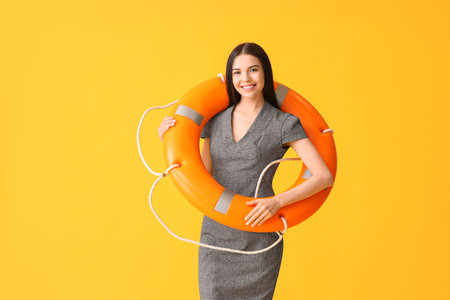 Young businesswoman with lifebuoy on color backgroundの写真素材