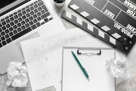 Clipboard with storyboard, laptop and movie clapper on grunge backgroundの写真素材