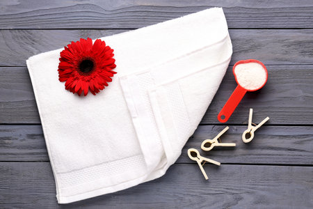 Laundry detergent, gerbera flower, clothespins and towel on gray wooden backgroundの写真素材
