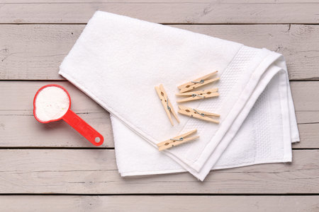 Laundry detergent, towel and clothes pins on wooden backgroundの写真素材