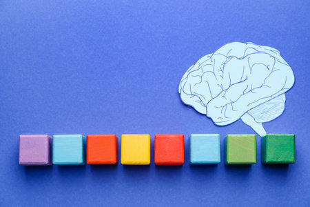 Cubes and paper brain on color background. Dyslexia conceptの写真素材