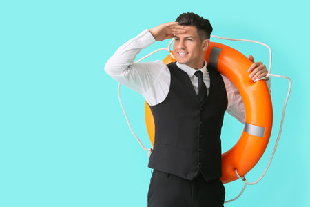 Young businessman with lifebuoy on color backgroundの写真素材