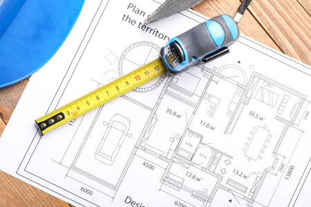 Measuring tape with blueprint on tableの写真素材