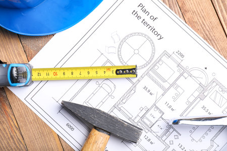 Measuring tape with builder's supplies and blueprint on tableの写真素材