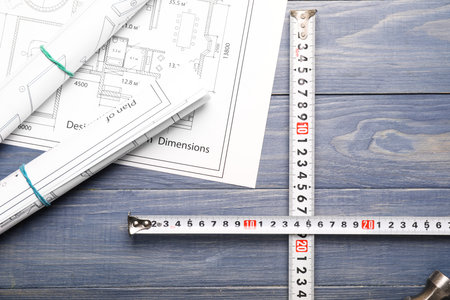 Measuring tapes with blueprints on tableの写真素材