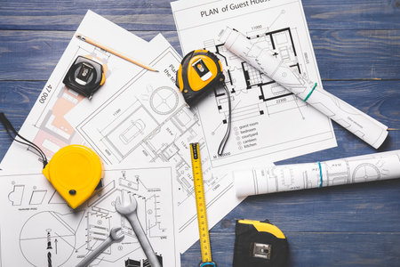 Measuring tapes with builder's supplies and blueprint on tableの写真素材