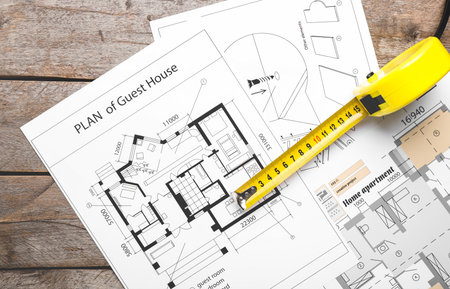 Measuring tape with blueprints on tableの写真素材